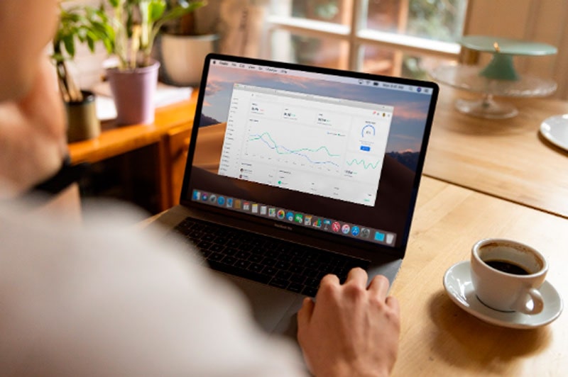 Man working on laptop and looking at charts
